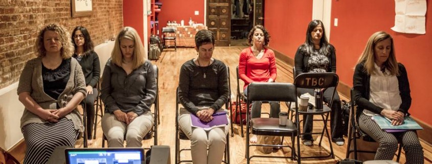 After removing their shoes, staffers of the nonprofit organization Care meditate at an Upbuild workshop. PHOTO: NATALIE KEYSSAR FOR THE WALL STREET JOURNAL